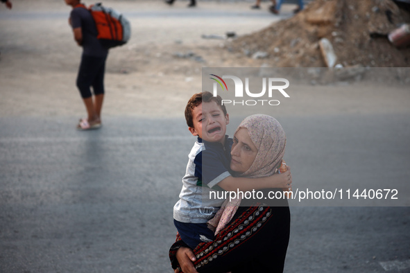 Displaced Palestinians are leaving al-Bureij refugee camp towards the west, after the Israeli army issued a new evacuation order, in the cen...