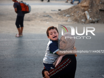 Displaced Palestinians are leaving al-Bureij refugee camp towards the west, after the Israeli army issued a new evacuation order, in the cen...