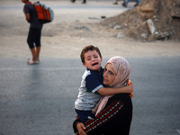 Displaced Palestinians are leaving al-Bureij refugee camp towards the west, after the Israeli army issued a new evacuation order, in the cen...