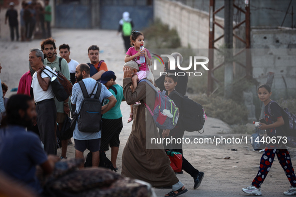 Displaced Palestinians are leaving al-Bureij refugee camp towards the west, after the Israeli army issued a new evacuation order, in the cen...