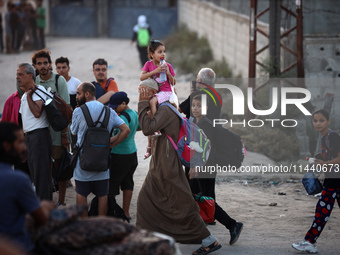 Displaced Palestinians are leaving al-Bureij refugee camp towards the west, after the Israeli army issued a new evacuation order, in the cen...