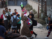 Displaced Palestinians are leaving al-Bureij refugee camp towards the west, after the Israeli army issued a new evacuation order, in the cen...