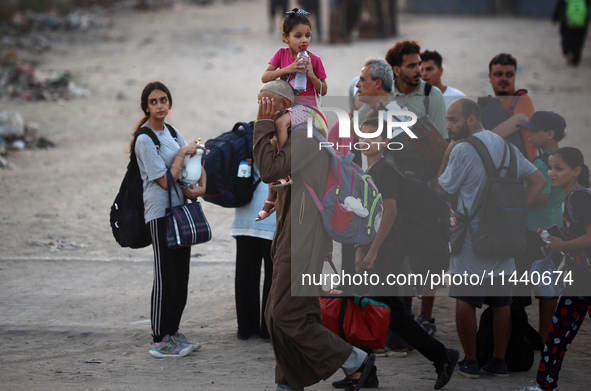 Displaced Palestinians are leaving al-Bureij refugee camp towards the west, after the Israeli army issued a new evacuation order, in the cen...