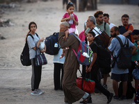 Displaced Palestinians are leaving al-Bureij refugee camp towards the west, after the Israeli army issued a new evacuation order, in the cen...