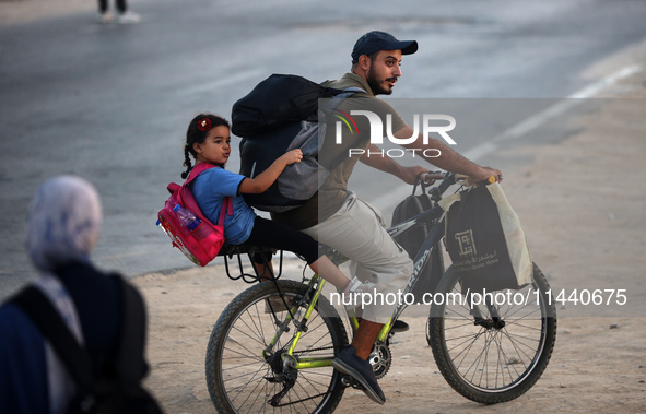 Displaced Palestinians are leaving al-Bureij refugee camp towards the west, after the Israeli army issued a new evacuation order, in the cen...