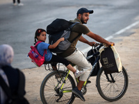 Displaced Palestinians are leaving al-Bureij refugee camp towards the west, after the Israeli army issued a new evacuation order, in the cen...