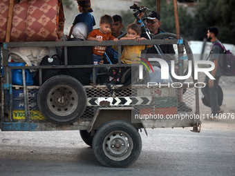 Displaced Palestinians are leaving al-Bureij refugee camp towards the west, after the Israeli army issued a new evacuation order, in the cen...