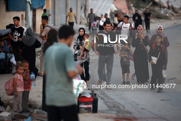 Displaced Palestinians are leaving al-Bureij refugee camp towards the west, after the Israeli army issued a new evacuation order, in the cen...