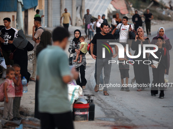 Displaced Palestinians are leaving al-Bureij refugee camp towards the west, after the Israeli army issued a new evacuation order, in the cen...