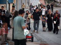 Displaced Palestinians are leaving al-Bureij refugee camp towards the west, after the Israeli army issued a new evacuation order, in the cen...