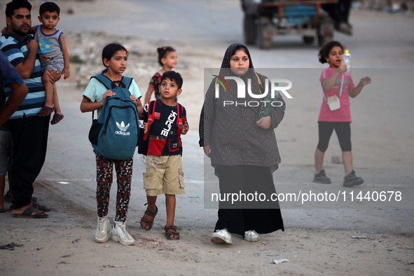 Displaced Palestinians are leaving al-Bureij refugee camp towards the west, after the Israeli army issued a new evacuation order, in the cen...