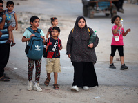 Displaced Palestinians are leaving al-Bureij refugee camp towards the west, after the Israeli army issued a new evacuation order, in the cen...