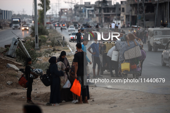 Displaced Palestinians are leaving al-Bureij refugee camp towards the west, after the Israeli army issued a new evacuation order, in the cen...