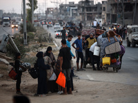 Displaced Palestinians are leaving al-Bureij refugee camp towards the west, after the Israeli army issued a new evacuation order, in the cen...