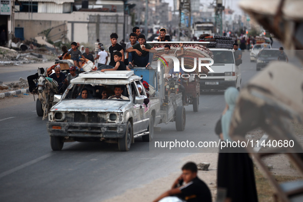 Displaced Palestinians are leaving al-Bureij refugee camp towards the west, after the Israeli army issued a new evacuation order, in the cen...