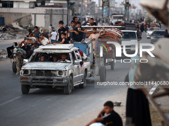 Displaced Palestinians are leaving al-Bureij refugee camp towards the west, after the Israeli army issued a new evacuation order, in the cen...