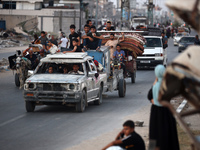 Displaced Palestinians are leaving al-Bureij refugee camp towards the west, after the Israeli army issued a new evacuation order, in the cen...