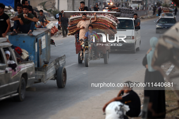 Displaced Palestinians are leaving al-Bureij refugee camp towards the west, after the Israeli army issued a new evacuation order, in the cen...