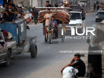 Displaced Palestinians are leaving al-Bureij refugee camp towards the west, after the Israeli army issued a new evacuation order, in the cen...