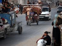 Displaced Palestinians are leaving al-Bureij refugee camp towards the west, after the Israeli army issued a new evacuation order, in the cen...