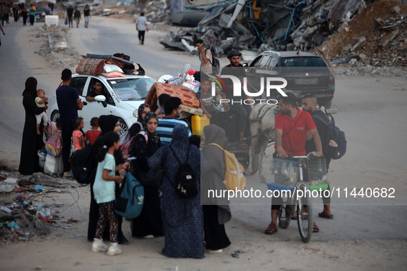 Displaced Palestinians are leaving al-Bureij refugee camp towards the west, after the Israeli army issued a new evacuation order, in the cen...