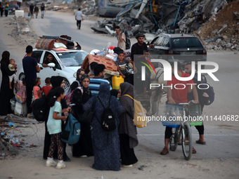 Displaced Palestinians are leaving al-Bureij refugee camp towards the west, after the Israeli army issued a new evacuation order, in the cen...