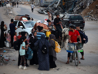 Displaced Palestinians are leaving al-Bureij refugee camp towards the west, after the Israeli army issued a new evacuation order, in the cen...