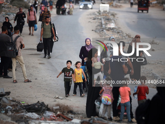 Displaced Palestinians are leaving al-Bureij refugee camp towards the west, after the Israeli army issued a new evacuation order, in the cen...