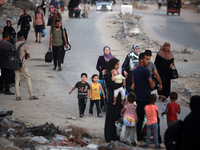 Displaced Palestinians are leaving al-Bureij refugee camp towards the west, after the Israeli army issued a new evacuation order, in the cen...