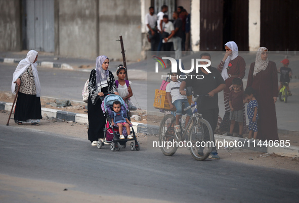 Displaced Palestinians are leaving al-Bureij refugee camp towards the west, after the Israeli army issued a new evacuation order, in the cen...