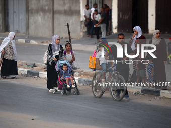 Displaced Palestinians are leaving al-Bureij refugee camp towards the west, after the Israeli army issued a new evacuation order, in the cen...