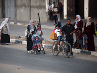 Displaced Palestinians are leaving al-Bureij refugee camp towards the west, after the Israeli army issued a new evacuation order, in the cen...