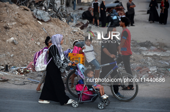 Displaced Palestinians are leaving al-Bureij refugee camp towards the west, after the Israeli army issued a new evacuation order, in the cen...