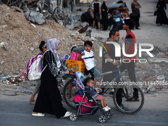 Displaced Palestinians are leaving al-Bureij refugee camp towards the west, after the Israeli army issued a new evacuation order, in the cen...