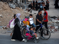 Displaced Palestinians are leaving al-Bureij refugee camp towards the west, after the Israeli army issued a new evacuation order, in the cen...