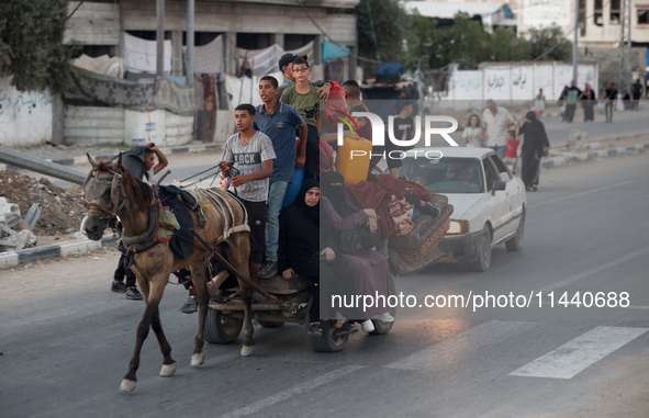 Displaced Palestinians are leaving al-Bureij refugee camp towards the west, after the Israeli army issued a new evacuation order, in the cen...