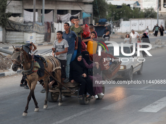 Displaced Palestinians are leaving al-Bureij refugee camp towards the west, after the Israeli army issued a new evacuation order, in the cen...