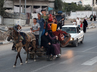 Displaced Palestinians are leaving al-Bureij refugee camp towards the west, after the Israeli army issued a new evacuation order, in the cen...