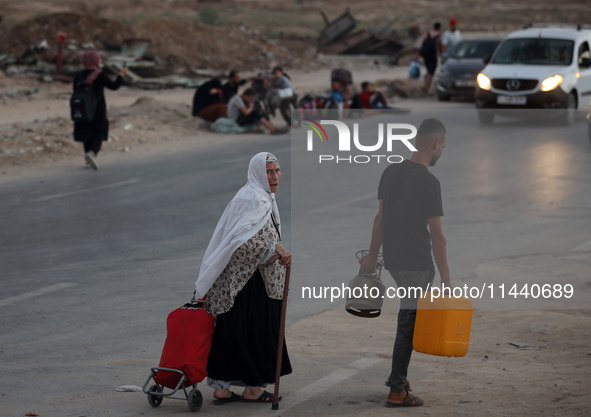 Displaced Palestinians are leaving al-Bureij refugee camp towards the west, after the Israeli army issued a new evacuation order, in the cen...