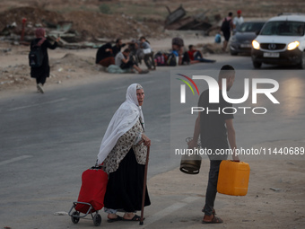 Displaced Palestinians are leaving al-Bureij refugee camp towards the west, after the Israeli army issued a new evacuation order, in the cen...