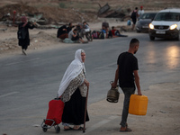 Displaced Palestinians are leaving al-Bureij refugee camp towards the west, after the Israeli army issued a new evacuation order, in the cen...