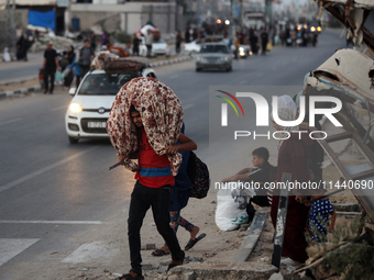 Displaced Palestinians are leaving al-Bureij refugee camp towards the west, after the Israeli army issued a new evacuation order, in the cen...