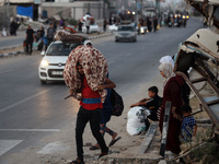 Displaced Palestinians are leaving al-Bureij refugee camp towards the west, after the Israeli army issued a new evacuation order, in the cen...