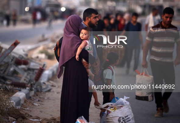 Displaced Palestinians are leaving al-Bureij refugee camp towards the west, after the Israeli army issued a new evacuation order, in the cen...