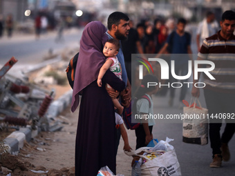 Displaced Palestinians are leaving al-Bureij refugee camp towards the west, after the Israeli army issued a new evacuation order, in the cen...