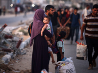 Displaced Palestinians are leaving al-Bureij refugee camp towards the west, after the Israeli army issued a new evacuation order, in the cen...