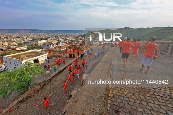 Kanwariyas are carrying holy water from the shrine 'Galta Peeth Tirtha' and going back to their pilgrimage in the auspicious month of 'Sharv...