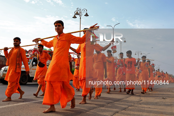 Kanwariyas are carrying holy water from the shrine 'Galta Peeth Tirtha' and going back to their pilgrimage in the auspicious month of 'Sharv...