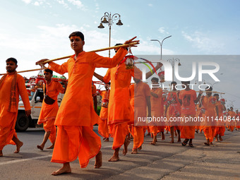 Kanwariyas are carrying holy water from the shrine 'Galta Peeth Tirtha' and going back to their pilgrimage in the auspicious month of 'Sharv...