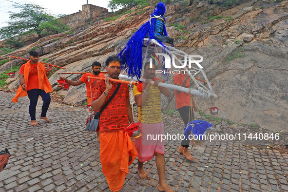 Kanwariyas are carrying holy water from the shrine 'Galta Peeth Tirtha' and going back to their pilgrimage in the auspicious month of 'Sharv...